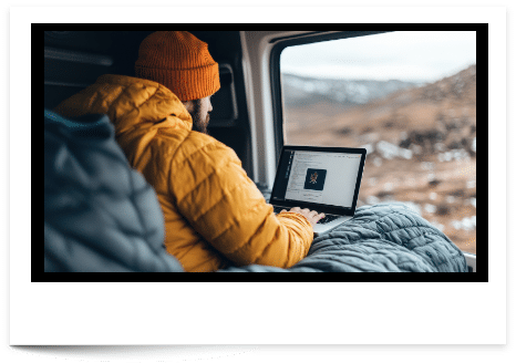 man in orange beaning camping and checking business website