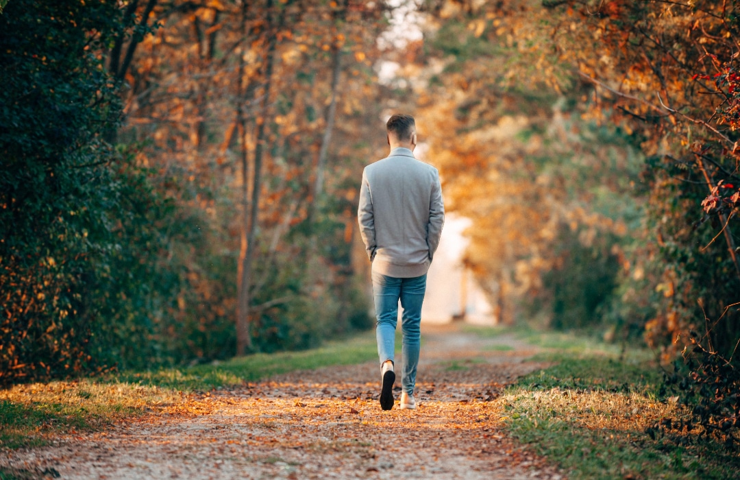 man walking on a path in the fall