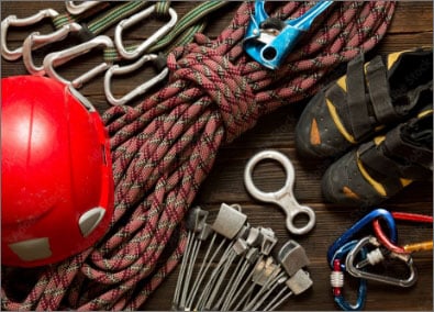 Top view of climbing and travel equipment on dark wooden background