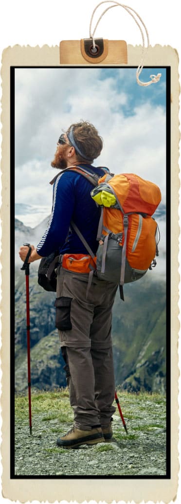 hiker with backpack stands on the trail in the Apls mountains.